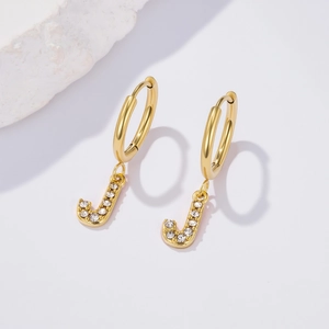 Detail of gold hoop earring with letter J pendant featuring micro-pave cubic zirconia stones
