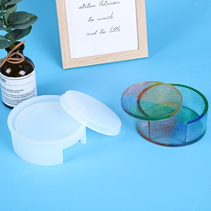 Detail of cylindrical silicone storage box mold with glitter resin crafts on blue background
