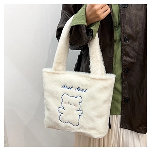 Détail du sac cabas en peluche blanche avec broderie ours bleu et texture fausse fourrure