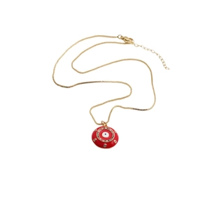 Dettaglio macro della collana placcata oro con ciondolo occhio del male rosso e zirconi