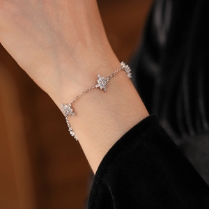 Gros plan d'un bracelet élégant en argent avec pendentif étoile et zircons au poignet