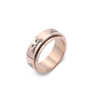 Detailed macro view of rotatable rose gold ring with engraved cat face motifs
