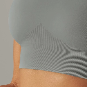 Close-up of seamless knitted texture and ribbed hem on light gray sports bra
