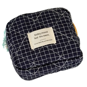 Quilted navy blue plaid storage pouch with cotton label and light green zipper detail