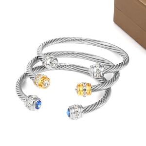 Detailed view of twisted steel cable bangles featuring sparkling crystal-set end caps