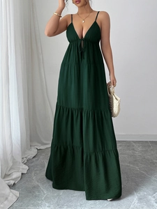 Detail of dark green maxi dress with deep V-neck, lace-up front and ruffled hemline