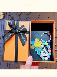 Close-up of rainbow sunflower beaded keychain with heart charm in a premium gift box