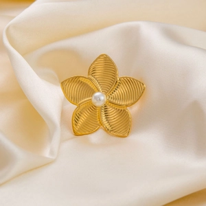 18K gold plated flower ring with central pearl on elegant silk fabric background