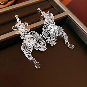 Close-up of hollow koi earrings with transparent waterdrop beads in a jewelry box