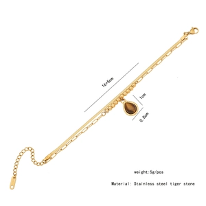 Detail view of double-layer stainless steel bracelet with tiger eye stone drop pendant