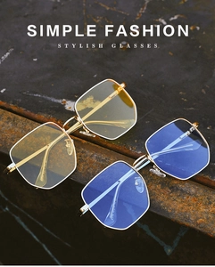 Detail of square gold metal sunglasses with yellow and blue-purple lenses on vintage surface