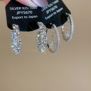 Macro shot of S925 silver C-shaped star earrings with pavé set sparkling crystals