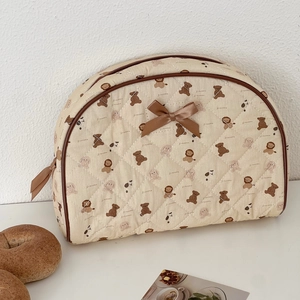 Detailed quilted texture of bear print toiletry bag with brown ribbon bow decoration