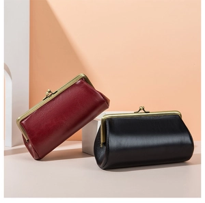 Close-up of vintage leather clutch bags in red and black with brass metal clasp frame