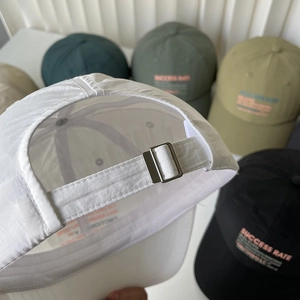Detail of adjustable metal buckle on quick-dry nylon baseball cap with embroidery