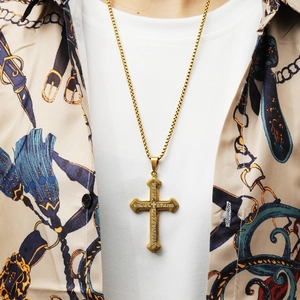 Close-up of golden stainless steel cross pendant necklace with engraved scripture