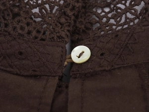 Detail of pearlescent button on dark coffee lace embroidery blouse for women