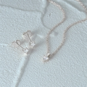 Detailed close-up of heart-shaped zircon jewelry set on a white stone background
