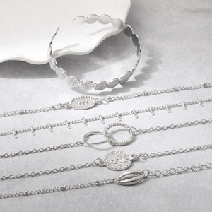Detailed set of silver-toned bracelets featuring shell charms and coin pendants