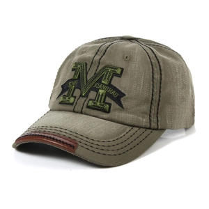 Detail of embroidered M letter on vintage green washed denim baseball cap for sun protection