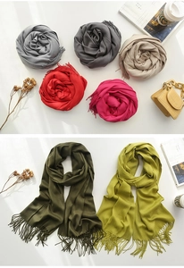 Detailed view of colorful cashmere feel scarves with tassels in multiple classic colors