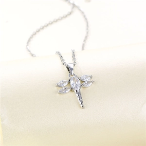 Silver dragonfly necklace with sparkling cubic zirconia on a beige backdrop