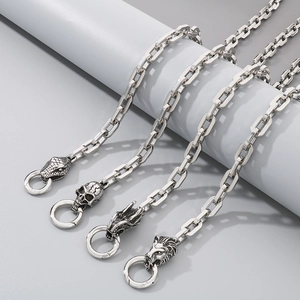 Detail of silver stainless steel chains featuring snake, skull, dragon, and lion heads