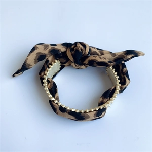 Detail of leopard print headband with gold bead trim and stylish knotted design