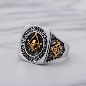 Macro detail of Freemason ring featuring gold skull emblem and engraved Latin motto