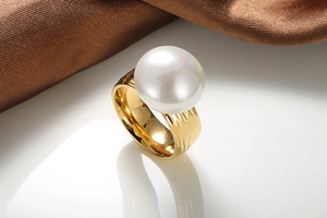 Detailed view of large white pearl on hammered gold stainless steel textured ring