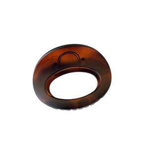 Minimalist oval tortoiseshell hair claw clip with dark brown resin pattern on white background
