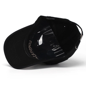 Internal structure of black cotton baseball cap showing embroidery and metal buckle strap
