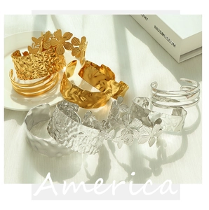Detailed macro view of gold and silver hammered texture adjustable open cuff bracelets
