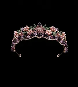 Detailed close-up of bridal crown with purple crystals and rose gold floral accents