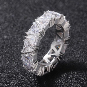 Macro close-up of a silver eternity ring with triangular-cut crystals on a black background