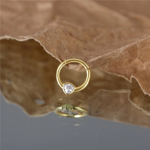 Macro shot of gold S925 sterling silver hoop with a sparkling triangular zircon stone