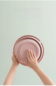 Foldable pink washbasin made of TPR material showing compact storage and durable base detail