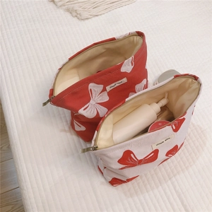 Internal view showing storage capacity of white canvas makeup bag with red bow prints