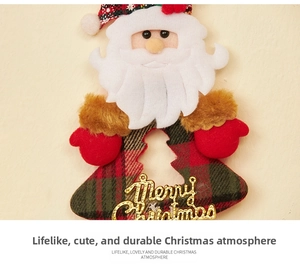 Close-up of Santa Claus plush pendant with gold Merry Christmas sign and red plaid patterns