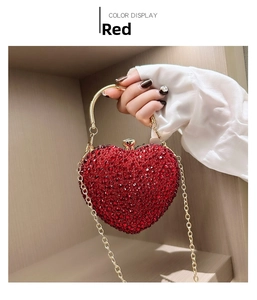 Close-up of red heart evening bag with crystal rhinestones and golden metal handle