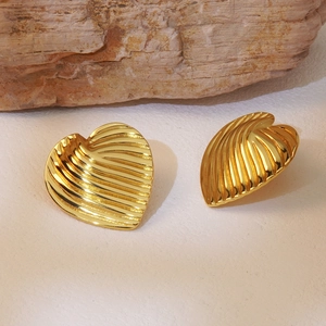 French style gold heart stud earrings with stylish wrinkled texture on stone background