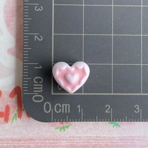 Mini pink resin heart charm on scale mat showing dimensions for DIY jewelry making