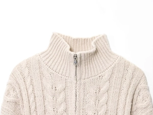 Detailed close-up of beige cable knit cardigan featuring a zipper and turtleneck design