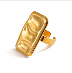 Close-up of 18k gold-plated ring with irregular lava texture and open-back square design