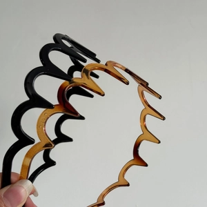 Detail of wavy non-slip headbands in solid black and tortoise shell finish for daily use