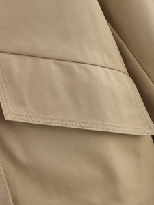 Close-up of double-stitched seams on khaki twill fabric trench coat detail