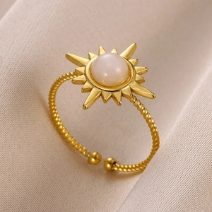 Detail of bohemian sun ring with white gemstone and twisted adjustable gold band
