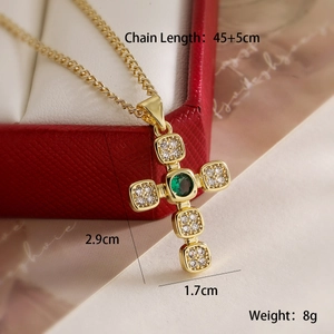 Macro shot of gold cross pendant with green gemstone and clear zircon dimensions