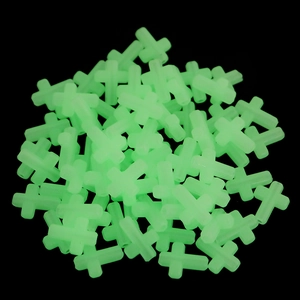 Luminous green cross beads for DIY jewelry making on a dark background