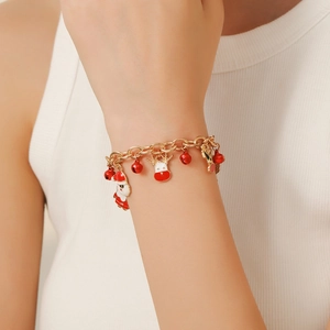 Close-up of Christmas charm bracelet with red bell, reindeer and Santa pendants